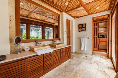 a bathroom with two sinks and two mirrors at Newly added Tropical Bungalow at Green Village in Punta Cana