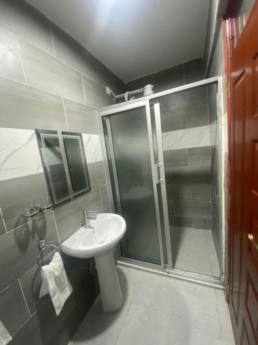 y baño con ducha y lavamanos. en Meru Heights Luxury Apartments, en Meru