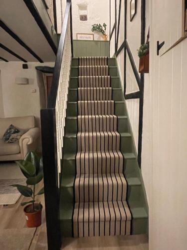 a stairway with green and white stairs in a room at Lilywood Cottage - 2BR Central Bicester in Bicester