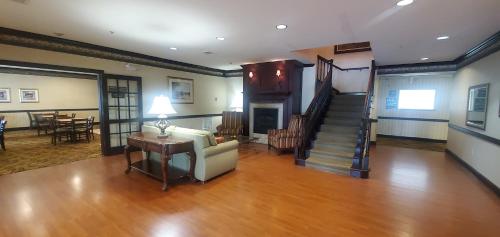 a living room with a staircase and a couch and a table at Wingate by Wyndham Youngstown - Austintown in Youngstown
