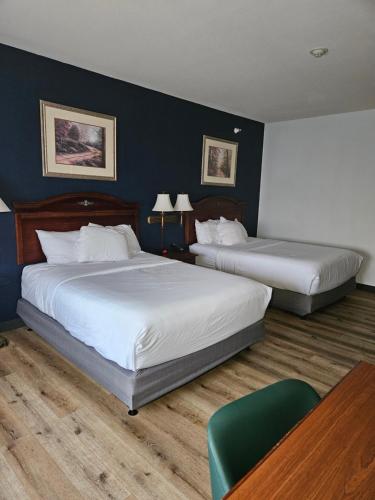 a hotel room with two beds and a table at Wingate by Wyndham Youngstown - Austintown in Youngstown