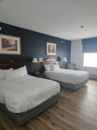 two beds in a hotel room with blue walls at Wingate by Wyndham Youngstown - Austintown in Youngstown