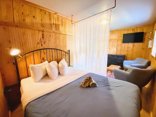 a bedroom with a bed and a chair and a television at Flathead Lake Resort in Bigfork