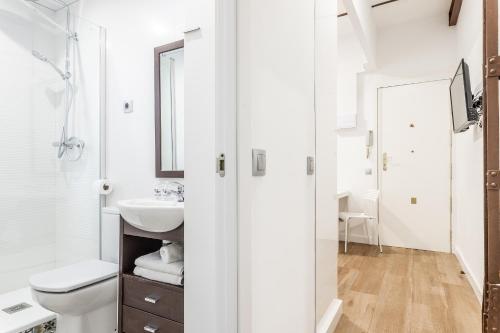 La salle de bains blanche est pourvue de toilettes et d'un lavabo. dans l'établissement BNBHolder Tropical CENTRE, à Madrid