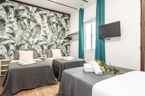Cette chambre comprend 3 lits et une fresque murale. dans l'établissement BNBHolder Tropical CENTRE, à Madrid