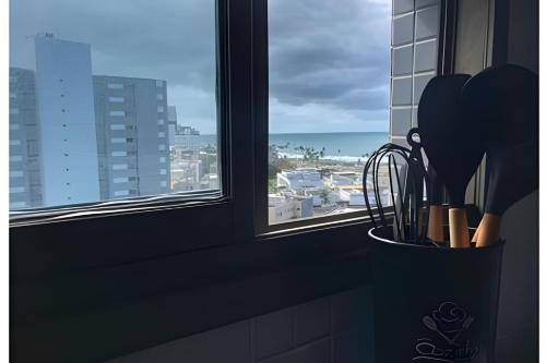 a kitchen window with a view of the ocean at New Studios by VLV Stays in Salvador