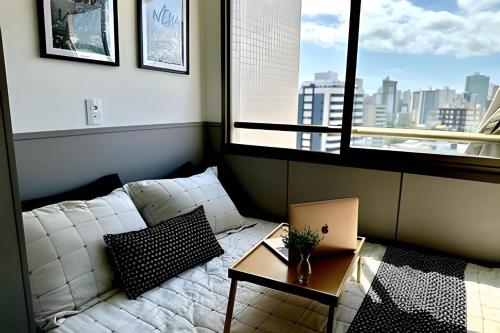 a living room with a white couch in front of a window at New Studios by VLV Stays in Salvador