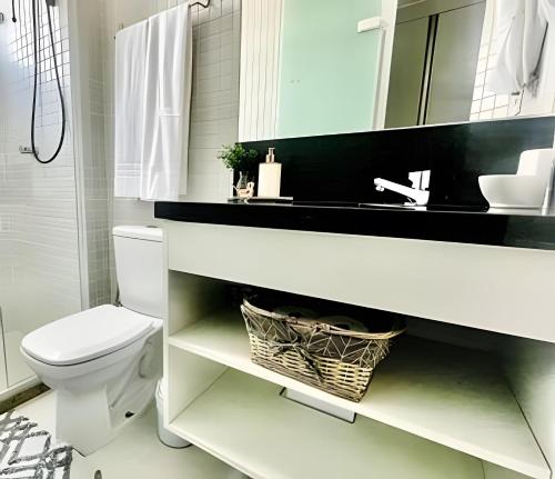 a bathroom with a sink and a toilet and a mirror at New Studios by VLV Stays in Salvador