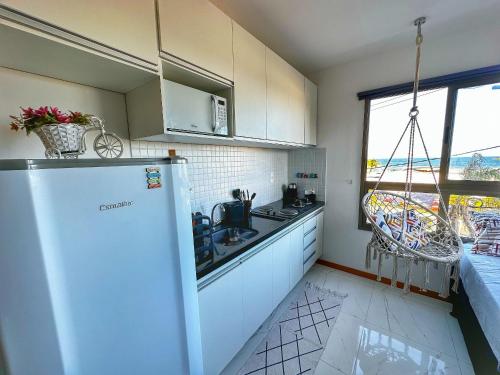 a kitchen with a refrigerator and a sink and a window at New Studios by VLV Stays in Salvador
