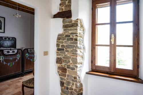 a stone wall in a living room with a window at B&B CorteBonomini entire home in Sasso