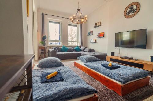 een woonkamer met 3 bedden en een televisie bij Urban Apartment - Stilvoll & im Herzen der Stadt in Bremerhaven