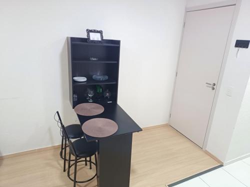 uma cozinha com um balcão preto com cadeiras e um frigorífico em Apê no Centro de Madureira no Rio de Janeiro