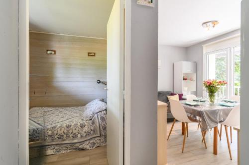 une chambre avec un lit et une table et une salle à manger dans l'établissement Pot de Résine - Appartement à 500m de la plage, à Arcachon