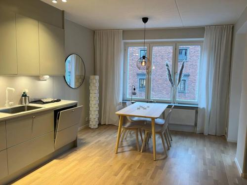 a kitchen with a table and chairs and a window at New apartment in Hagastaden in Stockholm