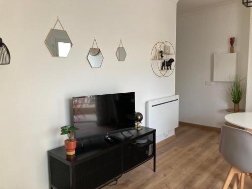 un salon avec une télévision à écran plat sur un mur dans l'établissement STUDIO à 50 mètres de la plage, à Antibes