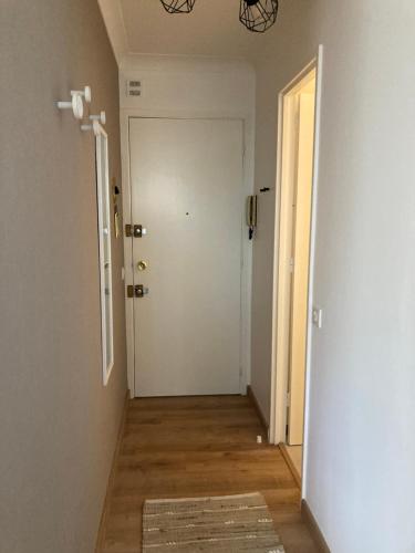 un couloir vide avec une porte blanche et un tapis dans l'établissement STUDIO à 50 mètres de la plage, à Antibes