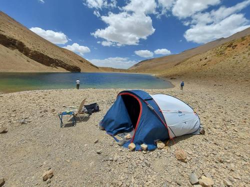 a tent on a beach next to a lake at Guest House Imdoukal in Aït Tamellil
