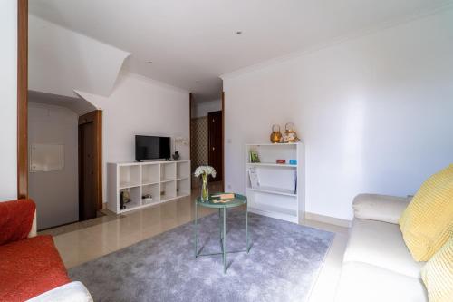a living room with a table and a couch at Taxa Duplex - T4 familiar no centro da cidade - Braga in Braga
