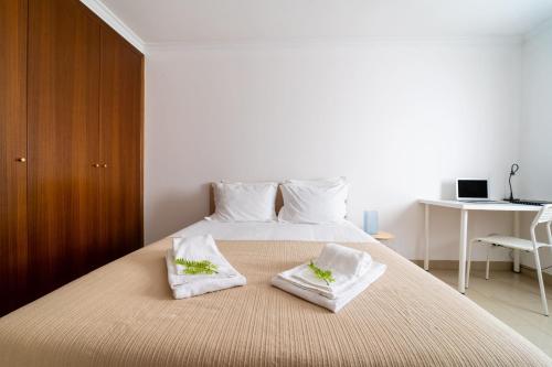 a bedroom with a bed with two towels on it at Taxa Duplex - T4 familiar no centro da cidade - Braga in Braga