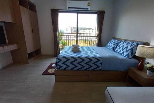 1 dormitorio con cama y ventana grande en ชีวิตมีความสุข สะดวกสบาย ที่ลากาสิต้าC368, en Hua Hin