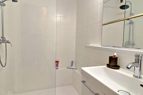 une salle de bain blanche avec une douche et un lavabo dans l'établissement Esterel Plage I Bord de mer Fréjus I Clim I 4 personnes, à Fréjus