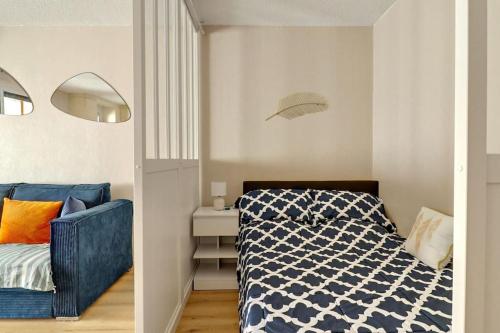 une chambre avec un lit et un canapé bleu dans l'établissement Esterel Plage I Bord de mer Fréjus I Clim I 4 personnes, à Fréjus