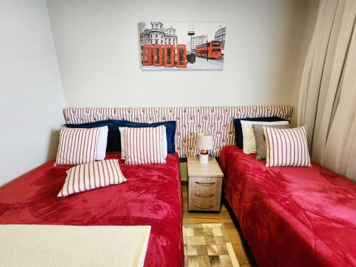 a bedroom with two beds with red sheets at Pousada Geada de Campos in Campos do Jordão