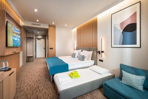 a hotel room with two beds and a couch at Park & Spa Hotel Markovo in Plovdiv