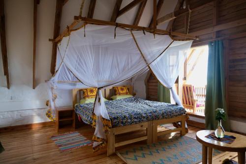 a bedroom with a bed with a canopy at Hyena Hill Lodge in Sanga