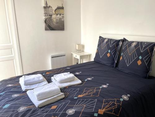 une chambre avec un lit avec des serviettes dessus dans l'établissement Escalille le Voltaire, à Lille