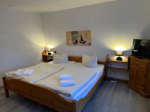 a bedroom with a bed with two towels on it at Pension Raststüb'l in Sorge