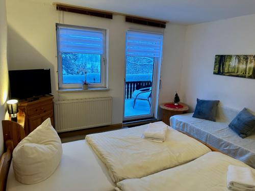 a living room with two beds and a television at Pension Raststüb'l in Sorge
