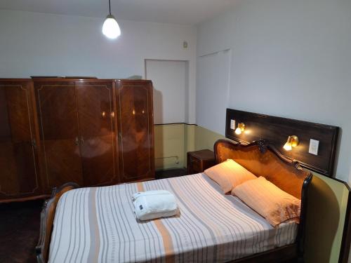 a bedroom with a large bed with a wooden headboard at La posada del Colibrí in Mendoza