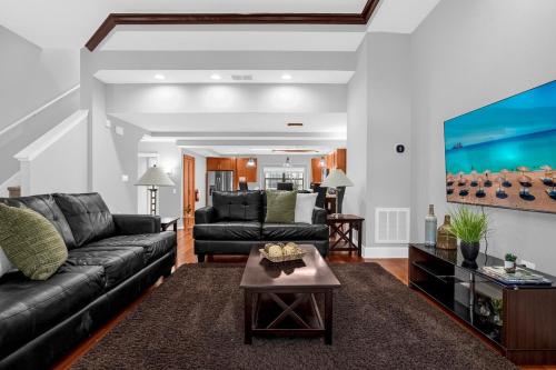 a living room with a couch and a table at Sunny Summer Awaits - Renovated Townhome by Disney! in Orlando