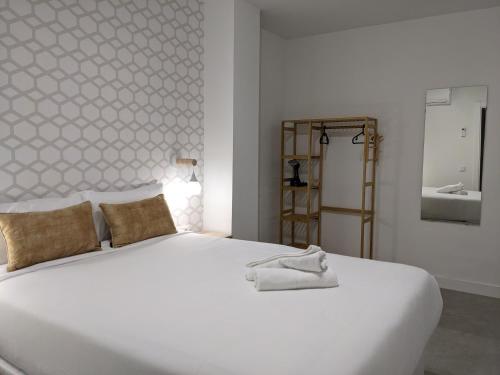 a white bed in a room with a sink at WEFLATING Fira in Hospitalet de Llobregat