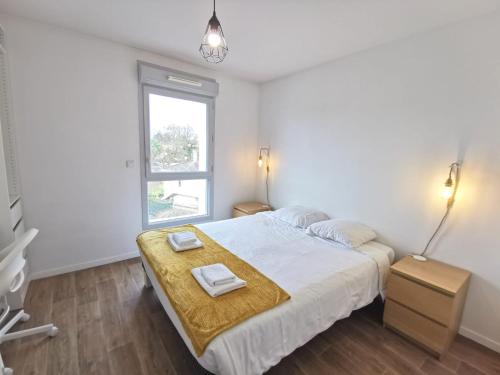 Schlafzimmer mit einem Bett und einem Fenster in der Unterkunft Joli deux pièces proche Nantes in Vertou