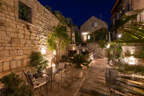an outdoor patio with benches and plants at night at Hotel San Giorgio in Vis