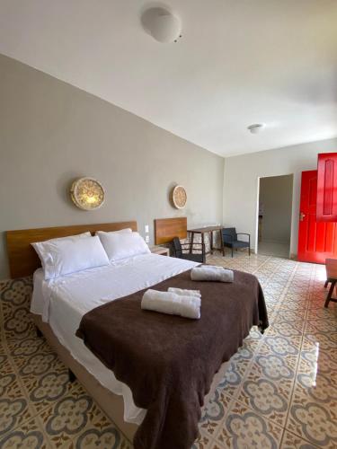 a bedroom with a large bed with two towels on it at Hospedagem Central in Tiradentes