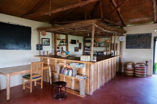 a bar with a chair and a chalkboard in a room at Hyena Hill Lodge in Sanga