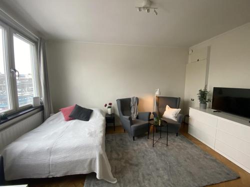 - une chambre avec un lit, deux chaises et une télévision dans l'établissement Cozy Ostermalm Studio, à Stockholm