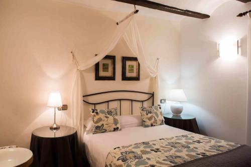 a bedroom with a bed with two tables and two lamps at Casa de la Cadena in Asiáin
