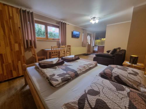 a bedroom with two beds and a living room at Wynajem u Andzi in Zakopane