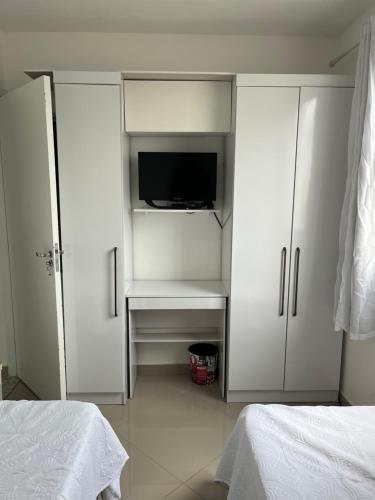 um quarto com dois armários brancos e uma televisão em Quarto ao Lado do autódromo de Interlagos em São Paulo