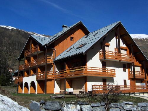 a large building with a roof on a mountain at Résidence Les Cordeliers - Studio pour 4 Personnes 171 in Valloire