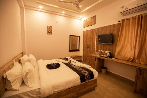 a hotel room with a bed and a television at Haridas Haveli by Charme Le Luxe in Udaipur