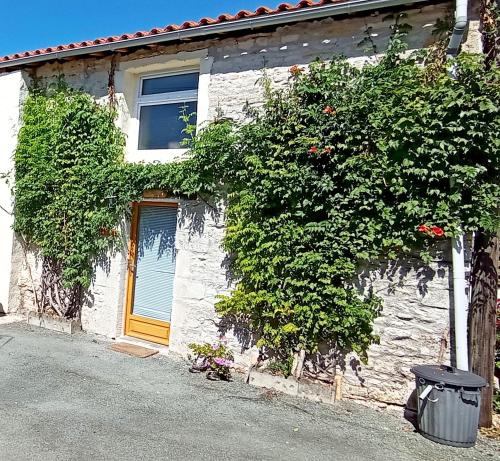 une maison en briques blanches avec une porte jaune dans l'établissement Ancien Chais, aire de loisirs avec piscine, à Marigny