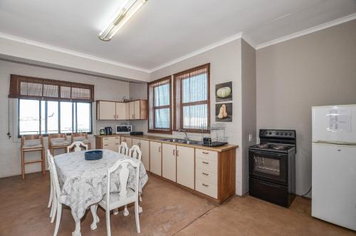a kitchen with a table and a stove and a refrigerator at NetReg in Yzerfontein