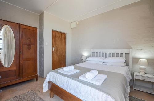 a white bedroom with a large bed with towels on it at NetReg in Yzerfontein