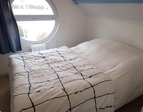 a bed in a bedroom with a window at La Vigie perchée - Les Gîtes de la Côte d'Amour in Le Croisic