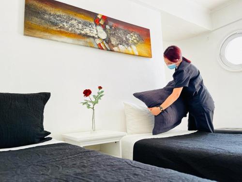 a woman with a face mask sitting on a bed at Tremo Bellas Artes in Santiago